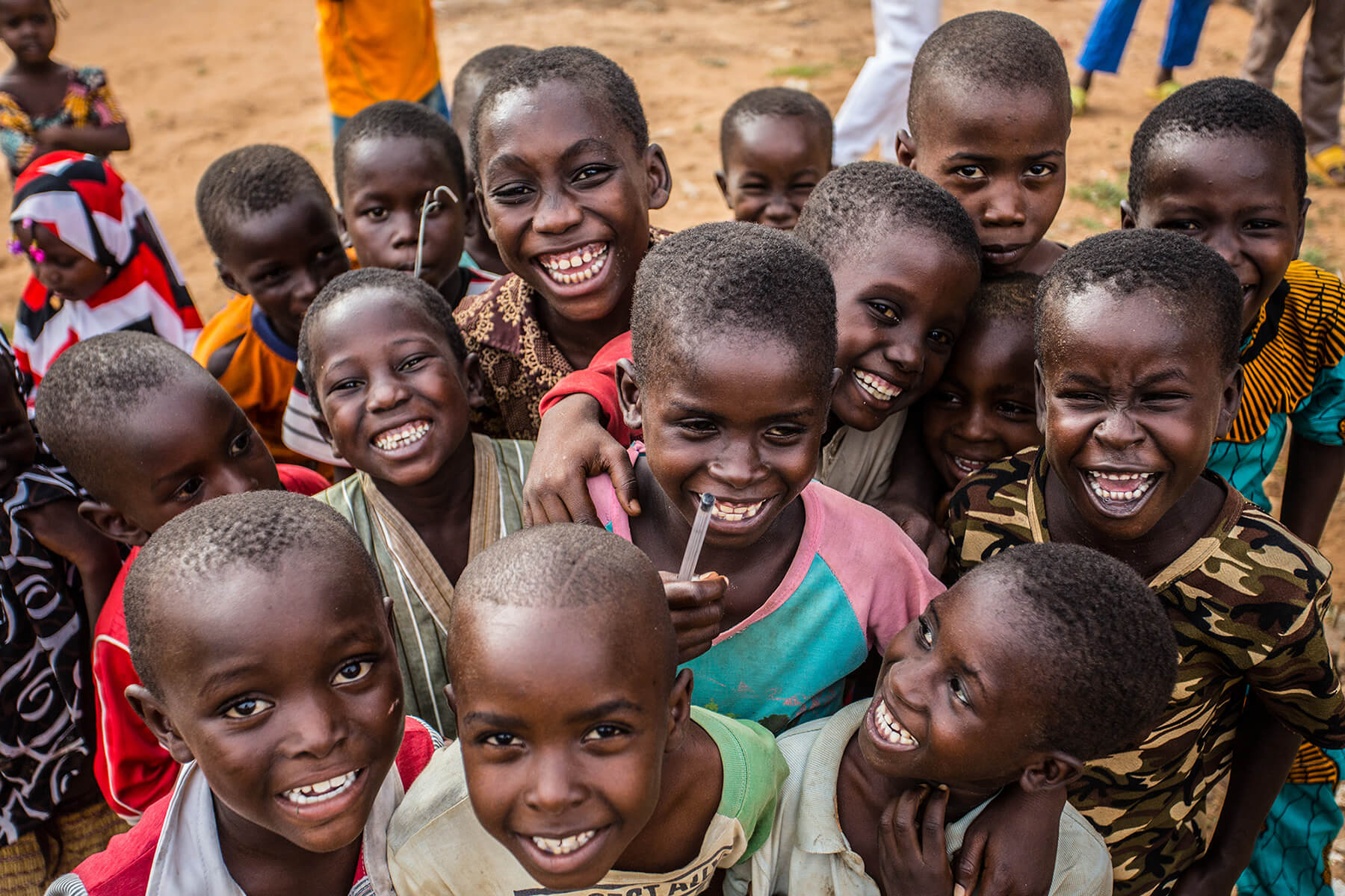 Smiling African children gathered outdoors, promoting community health and malaria awareness